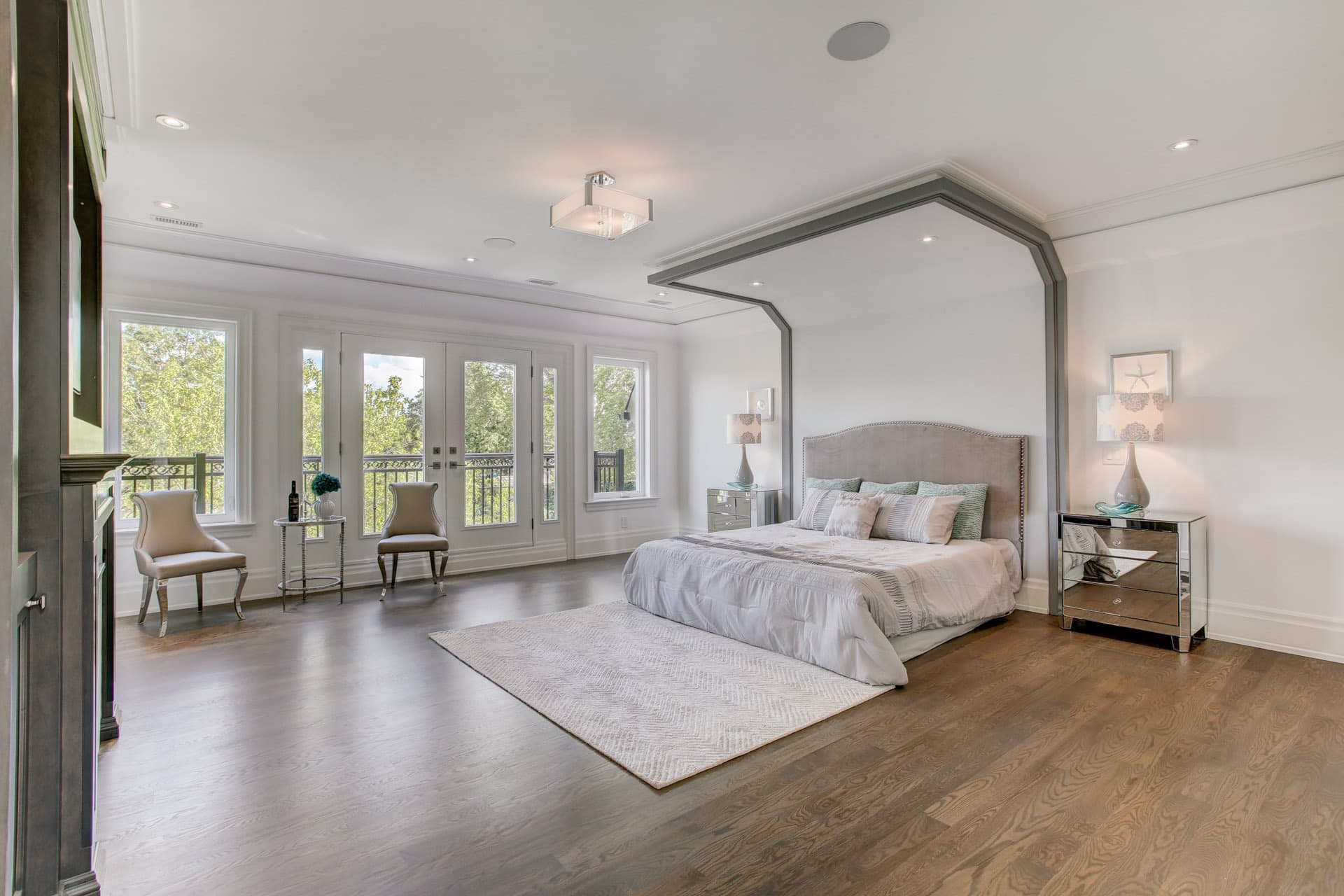 Principal bedroom with an arched trimmed bed alcove and French doors
