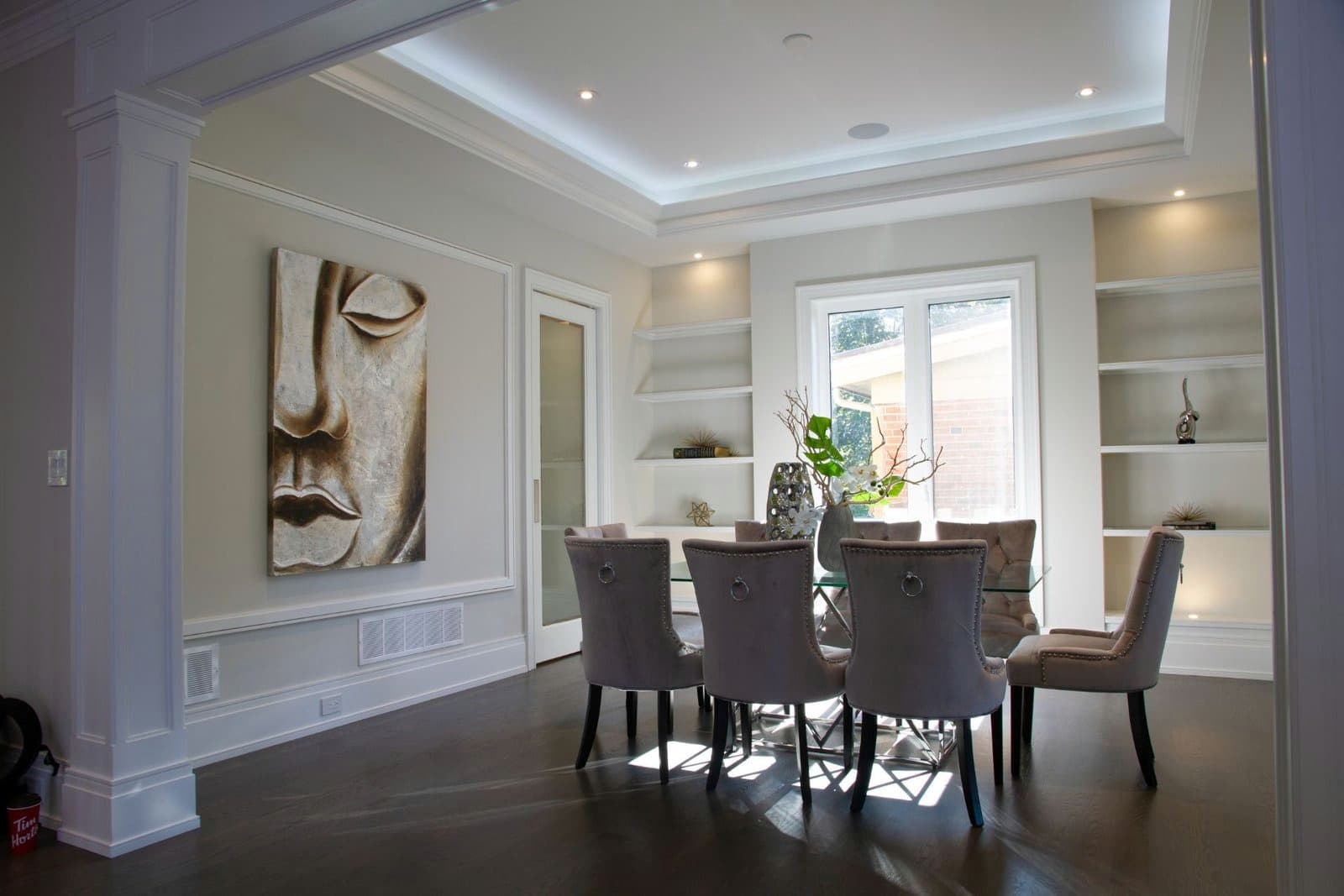Dining room with panelled walls, painted columns and built in niche shelving