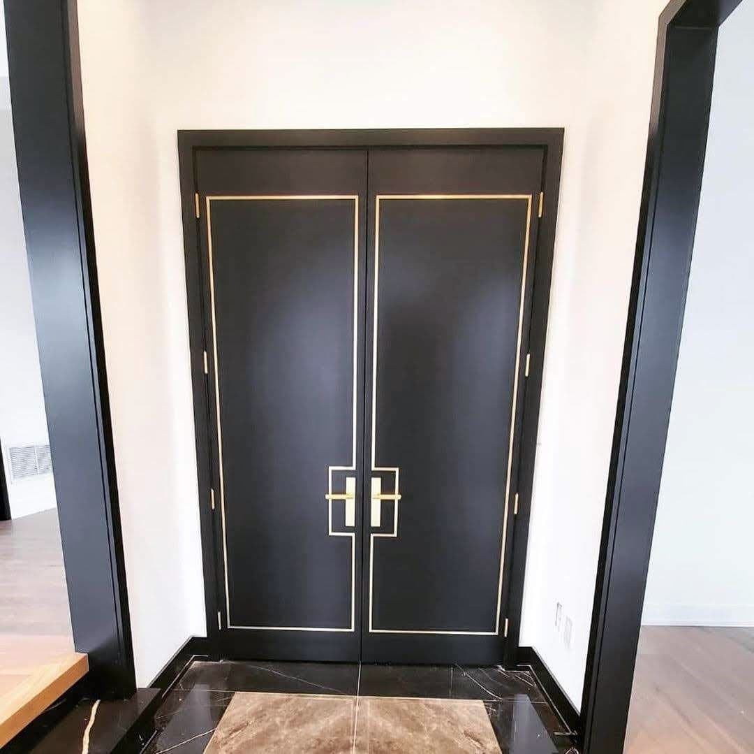 Black double doors with brass inlay lines and matching black casing