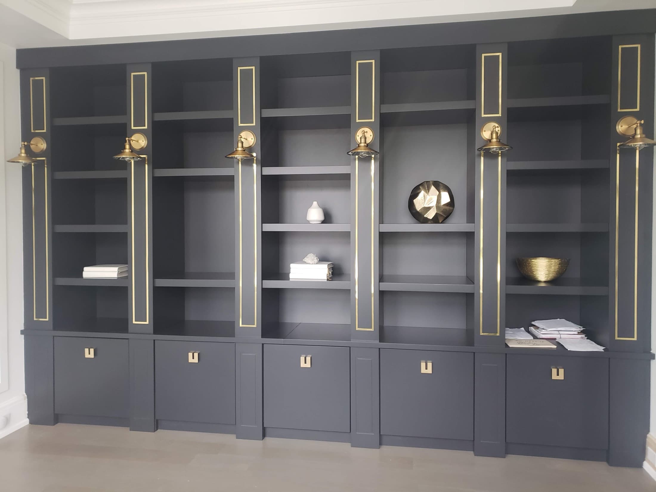 Charcoal built in bookcase with brass picture lights and inlaid gold lines