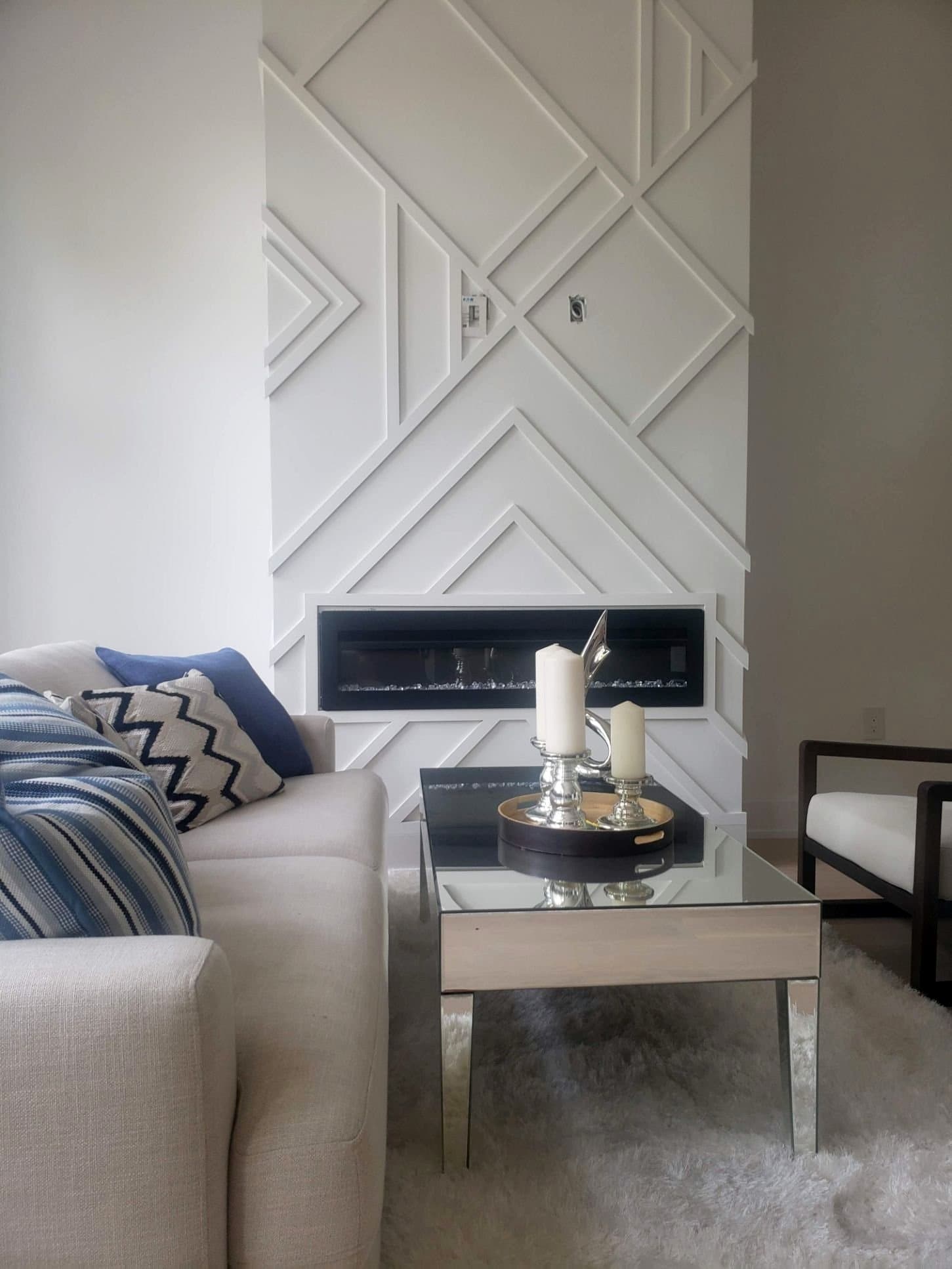 Living room feature wall with diagonal geometric panelling around a linear fireplace