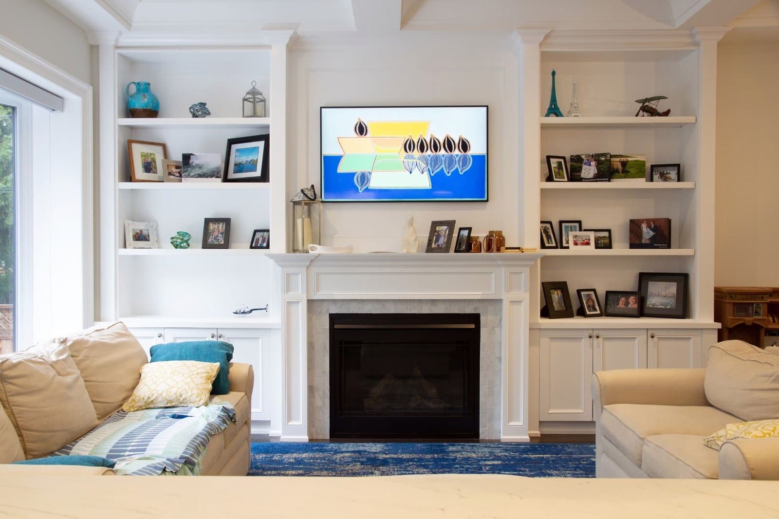 White built in wall unit with floating shelves either side of a fireplace