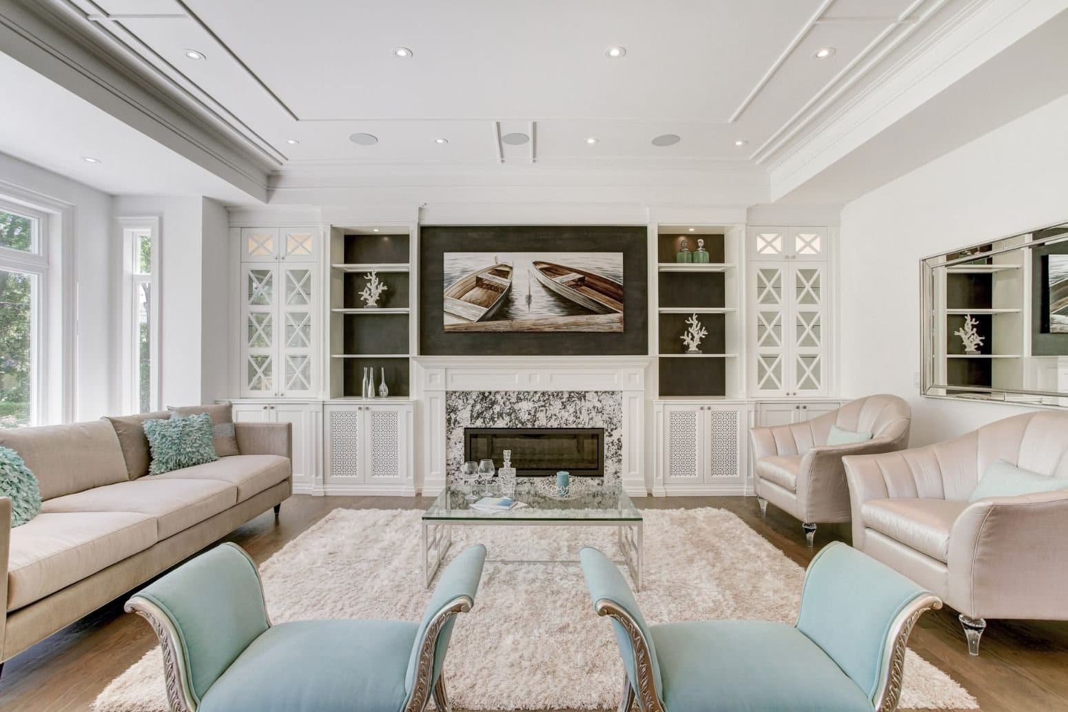White built in wall unit with glazed cabinets and open shelving flanking a marble fireplace