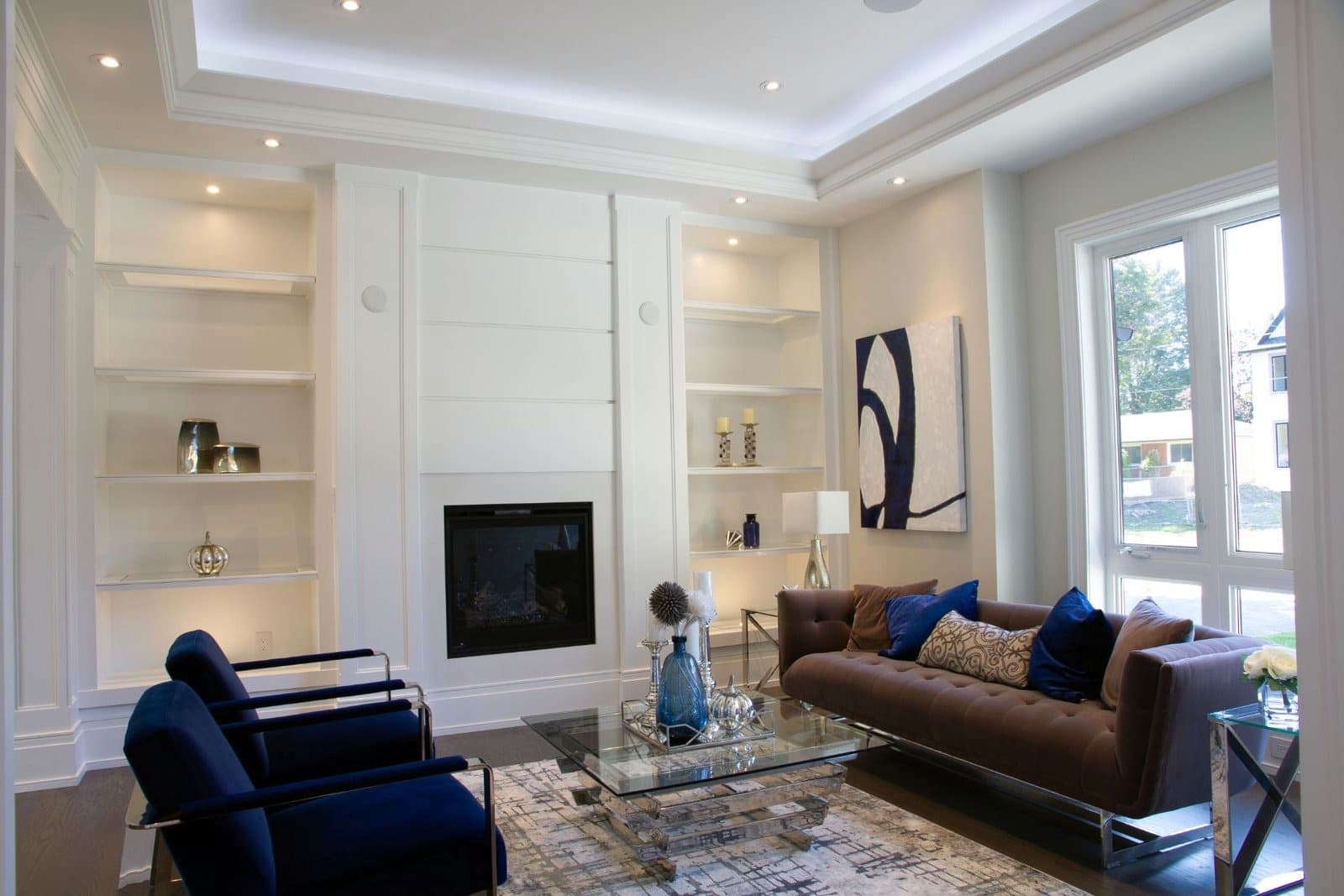 White built in shelving either side of a shiplap fireplace panel