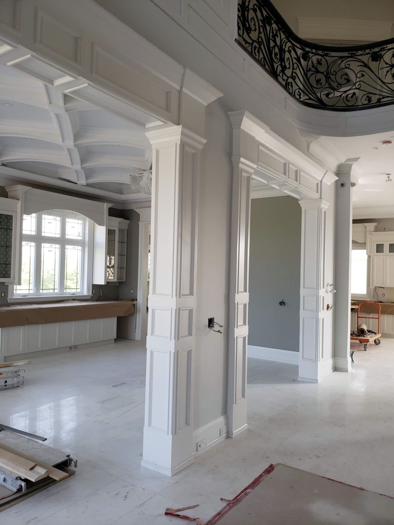 Panelled columns and a cased opening during installation, with the floor protected